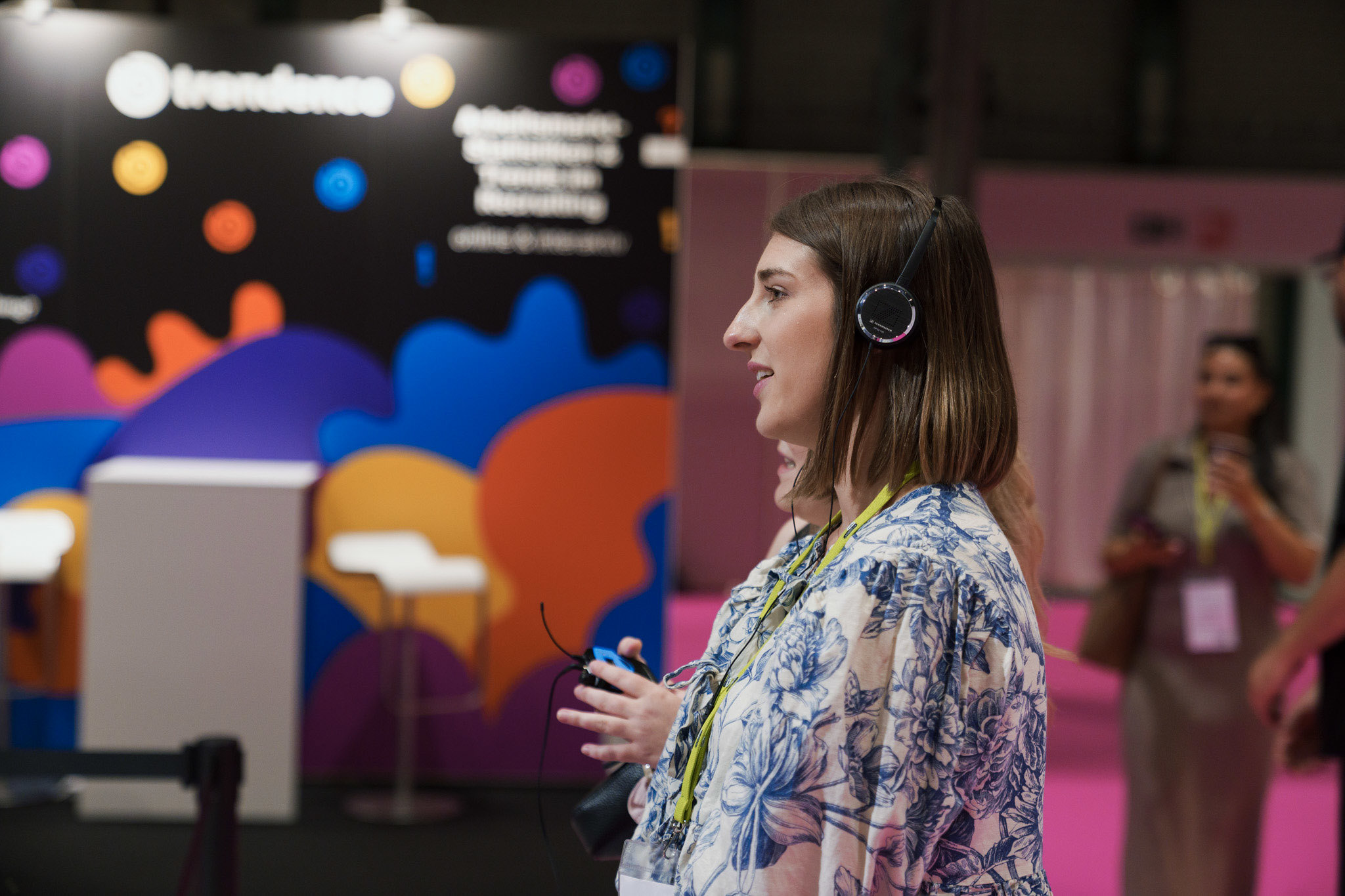 Moderator mit Headset vor einem farbigen gebrandeten Messestand auf der TALENTpro
